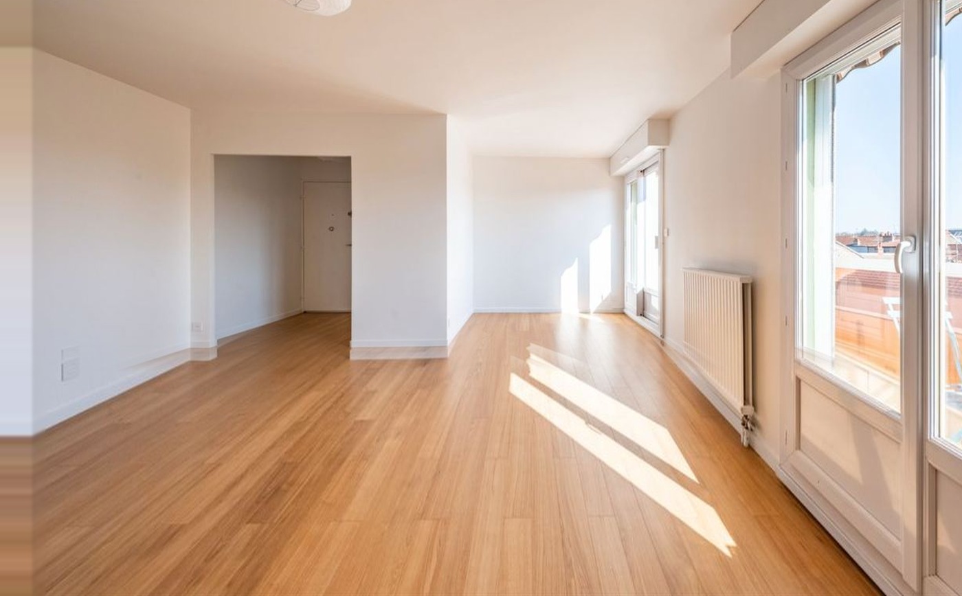 Le même séjour avant le projet : pièce vide, parquet clair et murs blancs